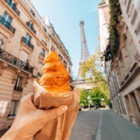 man holding croissant next to eiffel tower, personal perspective view, paris, france - food stock pictures, royalty-free photos & images