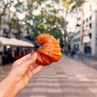 man holding fresh croissant on la rambla street, barcelona, spain - junk food stock pictures, royalty-free photos & images