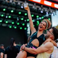 man holding girlfriends in arms at concert - concert stock pictures, royalty-free photos & images