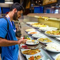 man in medical scrubs eating at a buffet style cafeteria - food stock pictures, royalty-free photos & images