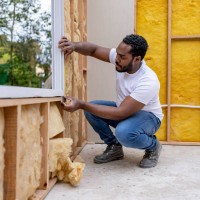 man installing a window while working as a volunteer building a house - home decoration stockfoto's en -beelden