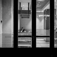 Man is sitting at a fast food restaurant in the city center of Milan, Italy, during the Christmas period, on December 21, 2023.