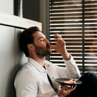 man licking fingers while eating food at home - food stock pictures, royalty-free photos & images