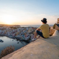 man looking at procida cityscape at sunset, gulf of naples, italy - travel stock pictures, royalty-free photos & images