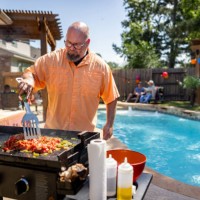man making mexican food while having a barbecue at home with his family - garden decoration stock pictures, royalty-free photos & images