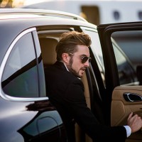 man on the airport opening car door - fashion stock pictures, royalty-free photos & images