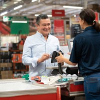 man paying by card at the cashier at a home improvement store - home decoration stock pictures, royalty-free photos & images