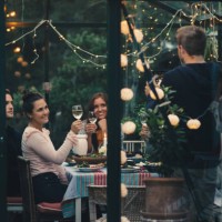 man photographing young friends raising toast with wineglasses during dinner party - garden decoration stock pictures, royalty-free photos & images