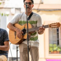 man playing a guitar and singing while performing on an outdoor stage. - concert stock pictures, royalty-free photos & images