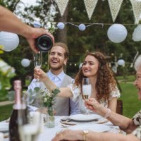 man pouring champagne into glasses for a toast at garden party. - garden decoration stock pictures, royalty-free photos & images