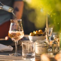 man pouring up rose wine at midsummer dinner - garden decoration stock pictures, royalty-free photos & images