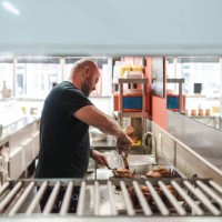 man preparing a delivery in a rotisserie shop - junk food stock pictures, royalty-free photos & images