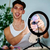 man putting on makeup in front of mobile phone using ring of light - fashion stock pictures, royalty-free photos & images