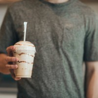 man's hand holding plastic cup of coffee delicacy - junk food stock pictures, royalty-free photos & images