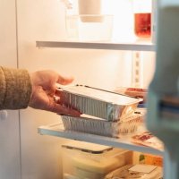 man's hand taking takeout meal out of refrigerator. - junk food stock pictures, royalty-free photos & images