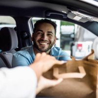 man smiles while picking up curbside order - junk food stock pictures, royalty-free photos & images