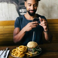 man taking photos of burger with smartphone - food stock pictures, royalty-free photos & images