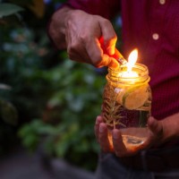 man using lemon scented floating candle as a natural mosquito repellant - garden decoration stock pictures, royalty-free photos & images