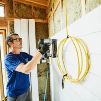 man using nail gun to install siding during home remodeling project - home decoration stock pictures, royalty-free photos & images