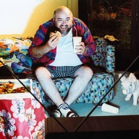 man watching tv and eating junk food - junk food stock pictures, royalty-free photos & images