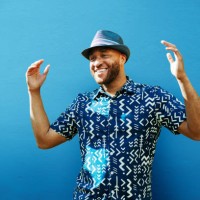 man with arms up, smiling, next to blue wall - fashion stock pictures, royalty-free photos & images