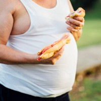 man with beer belly holding sandwich - junk food stock pictures, royalty-free photos & images