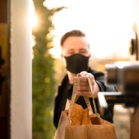 man with face mask delivering food - junk food stock pictures, royalty-free photos & images