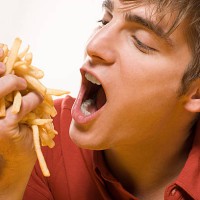 man with handful of fries - junk food stock pictures, royalty-free photos & images