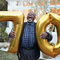 man with number 70 balloons laughing in backyard - garden decoration stock pictures, royalty-free photos & images