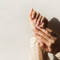 manicure on female hands with light pink nail polish. - nails art stock pictures, royalty-free photos & images