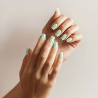 manicure on female hands with trendy green color of the year, pantone nail polish. - nails art stock pictures, royalty-free photos & images