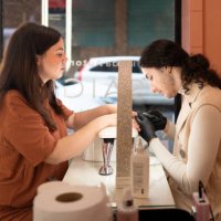 manicurist is giving a manicure to a customer in a beauty salon - nails art photos et images de collection