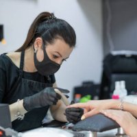 manicurist using an electric nail file to remove cuticles in the beauty salon - nails art stock pictures, royalty-free photos & images
