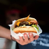 mans hand serving hamburger from fast food van - junk food stock pictures, royalty-free photos & images
