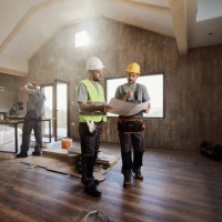 manual workers examining housing plan at construction site. - home decoration stock pictures, royalty-free photos & images
