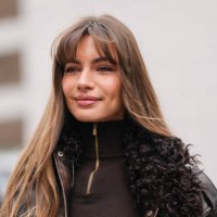 Mara LaFontan wears, deep dark brown half zipped turtleneck long sleeve sweater, shiny dark brown dark brown faux fur leather Michael Kors jacket,...