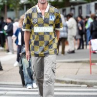 Marc Forne wears Nike baseball cap hat, Louis Vuitton sports jersey shirt with checkered pattern/print and Louis Vuitton patches, gray cargo pants,...