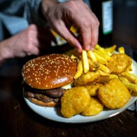 March 2025, Bremen: ILLUSTRATION - A burger, fries and nuggets on a plate. Photo: Sina Schuldt/dpa