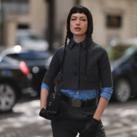 Maria Bottle is seen wearing a complete outfit from Miu Miu, consisting of a grey cropped jacket with ribbed trims, a black button placket, and a...