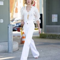 Maria Olympia of Greece and Denmark wears a gold necklace, a white lace puffy sleeves shirt, beige heels, white high waist flared trousers and a gold...