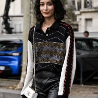 Maria Shindo is seen wearing a Chanel print top, black faux leather shorts and a white Chanel mini-bag outside the Chanel show during the Womenswear...