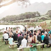 mariage, nature et groupe de famille et d’amis à la cérémonie dans un jardin du lac pour la célébration. l’amour, le plein air et les invités qui regardent un couple se marier lors d’un événement de luxe, élégant et de mariag