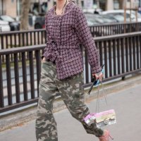 Marianne Theodorse wears pink tweed jacket, military print pants, sequins Chanel bag, pink heels, outside Chanel, during the Womenswear Fall/Winter...