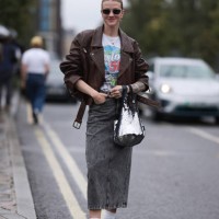 Marianne Theodorsen was seen wearing white adidas shoes and socks, a long denim grey jeans skirt, a shiny silver bag, dark shades, an oversized brown...