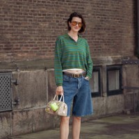 Marianne Theodorsen wears blue denim shorts, pink pointy shoes, green long sleeve shirt and orange sunglasses outside the Mark Kenly Domino Tan show...