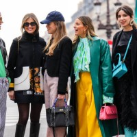 Marianne Theodorsen wears orange sunglasses, gold and silver chain pendant necklace, a yellow and green pearls necklace, a blue t-shirt, a green wool...