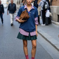 Marina Suarez wears brown suede bag, navy polo, green skirt outside Lacoste during Womenswear Spring/Summer 2025 as part of Paris Fashion Week on...