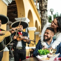 married couple listening to mariachi music at a restaurant outdoors - food stock pictures, royalty-free photos & images