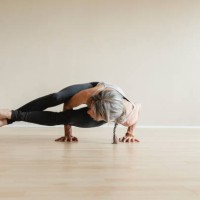 master yoga woman doing eight-angle pose, astavakrasana. - fashion stock pictures, royalty-free photos & images