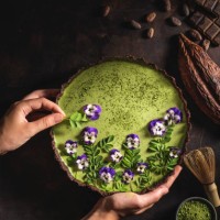 matcha tea and chocolate superfood tart moringa and pansy flowers - food stock pictures, royalty-free photos & images